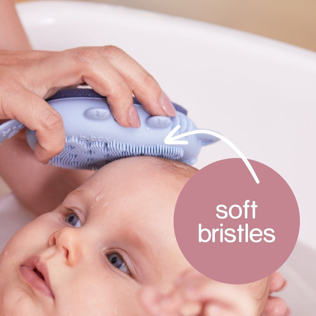 Hand scrubbing the Silicone Baby Bath Brush's Soft Bristles on Baby's Wet Head